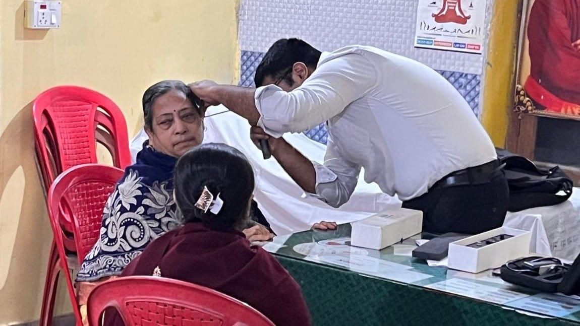 A Krancer doctor examining a patient during an outreach visit in a community hall