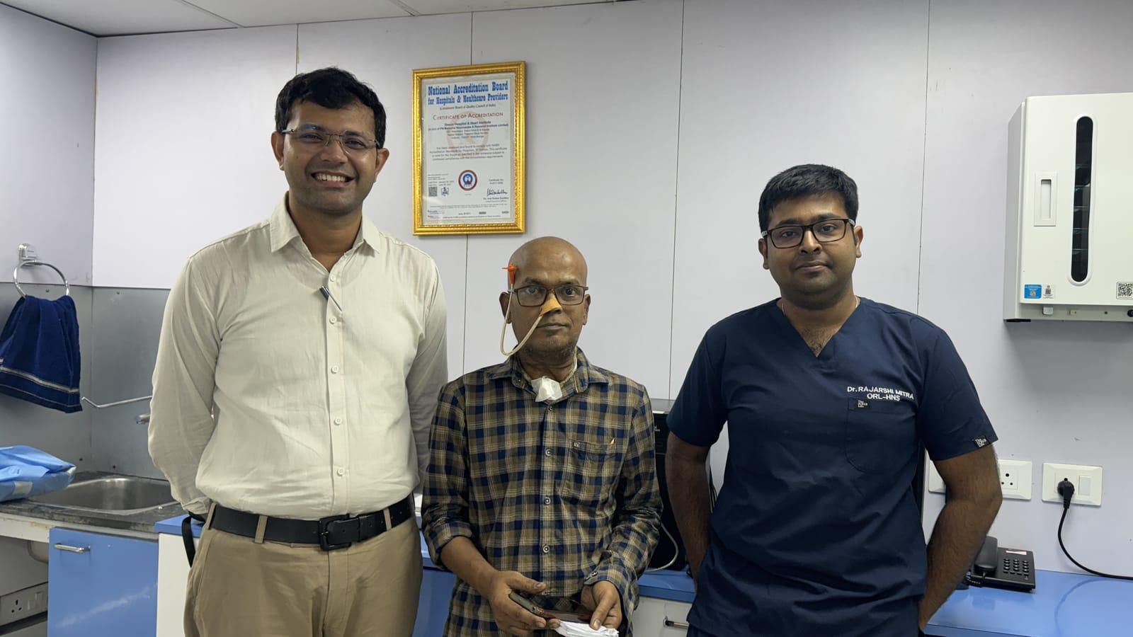 A patient standing between two Krancer doctors in a clinic room